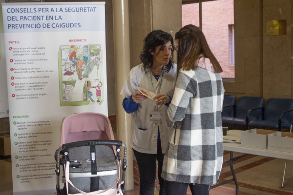 Professional d'infermeria parlant explicant la campanya de sensibilització sobre la prevenció de les caigudes a una usuaria.