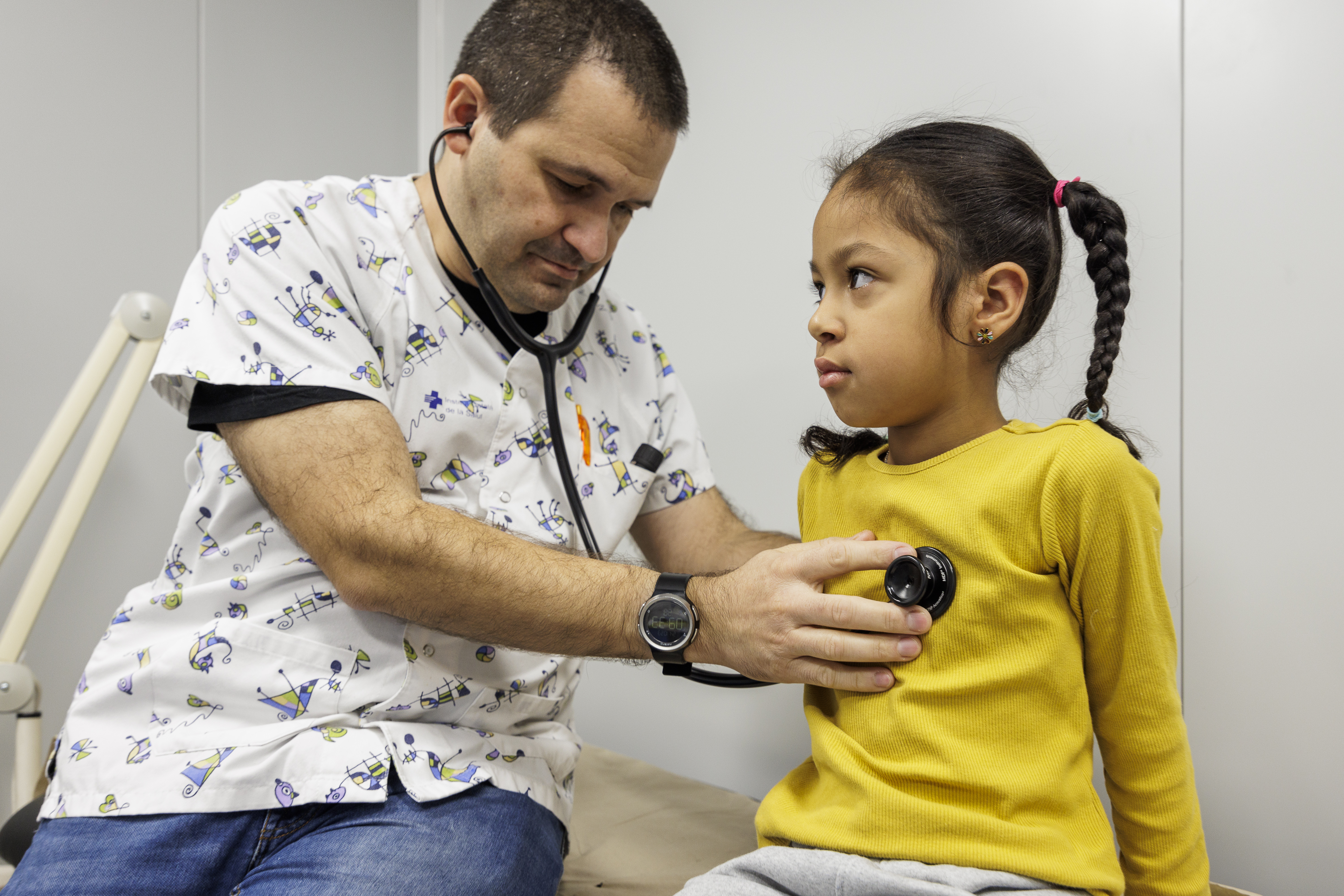 Un doctor explorant una nena a Pediatria d'Olot.
