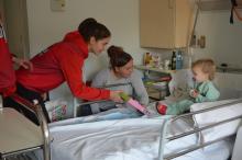 Jugadores de l'equip de bàsquet femení UNI Girona Spar Citylift visitant un nen ingressat a Pediatria